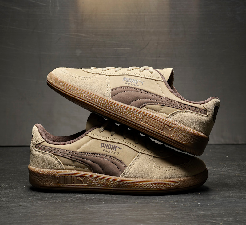 Beige og brune Puma Palermo sneakers i semsket skinn med gummiyttersåle, plassert på mørk bakgrunn.