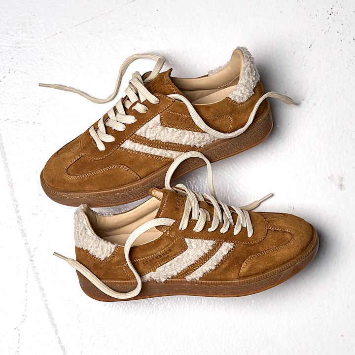 Brune retro-sneakers i semsket skinn med kremhvite teddy-detaljer, snørebånd og gummisåle. Casual og varm stil.