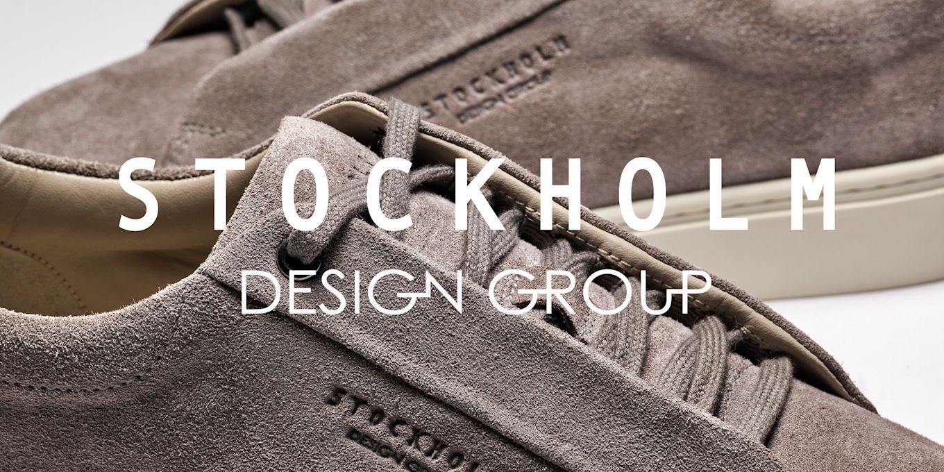 Grå semsket skinnsko fra Stockholm Design Group, med matchende lisser og kremfarget såle, vist i nærbilde.