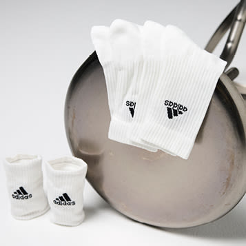 Hvite Adidas sportsokker, plassert på en metallisk krakk.