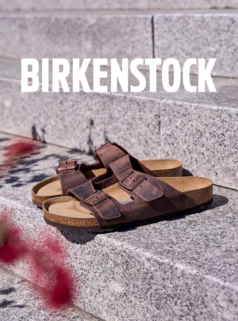 Birkenstock Arizona sandaler i brun oljet lær med to spennestropper og korksåle, plassert på grå granitttrapper.