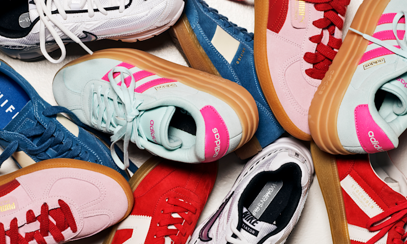 Flere fargerike sneakers fra merker som Adidas, Puma og Nike ligger tett sammen på en hvit bakgrunn.