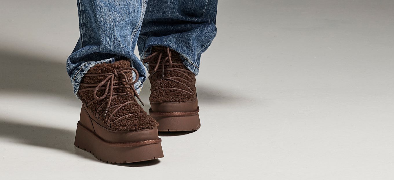 Brune, lodne ankelstøvletter med plattformsåle og snøring, brukt sammen med blå jeans.