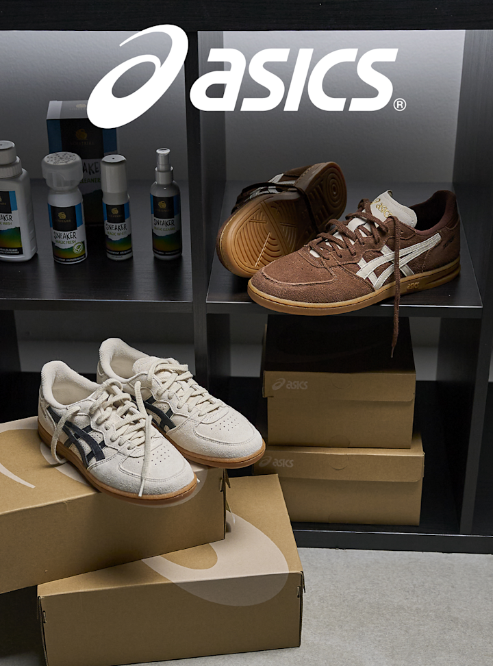 Asics-utstilling med brune og hvite sneakers i retrostil på hyller med esker. Skoene har gummisåler og klassisk design.